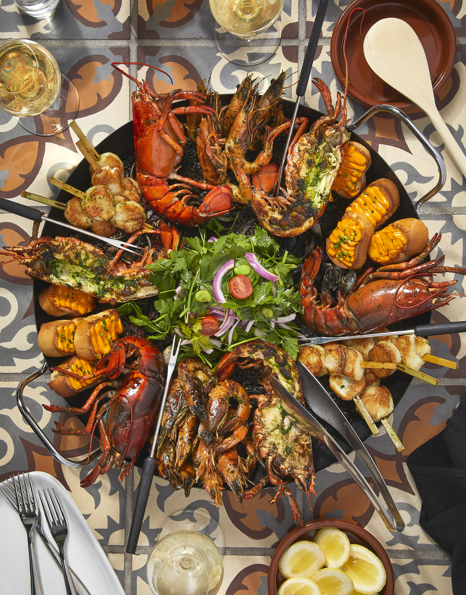 A New Year’s Eve seafood spread featuring lobster, shrimp, scallops, and grilled seafood served family-style.