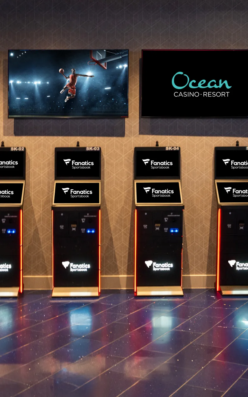 Fanatics Sportsbook self-service betting kiosks at Ocean Casino Resort with live sports displayed on overhead screens for easy in-person wagering.