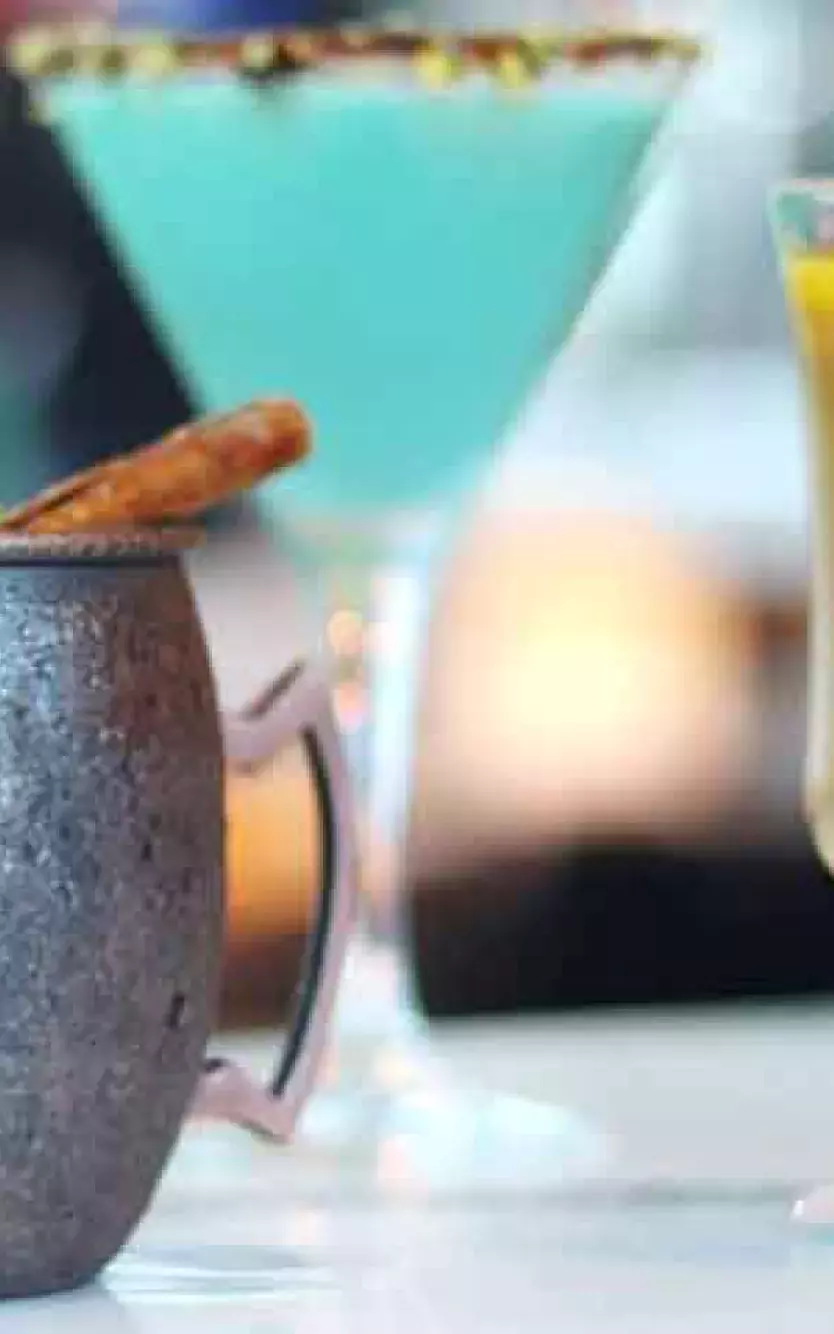 lineup of colorful cocktails sitting on a counter