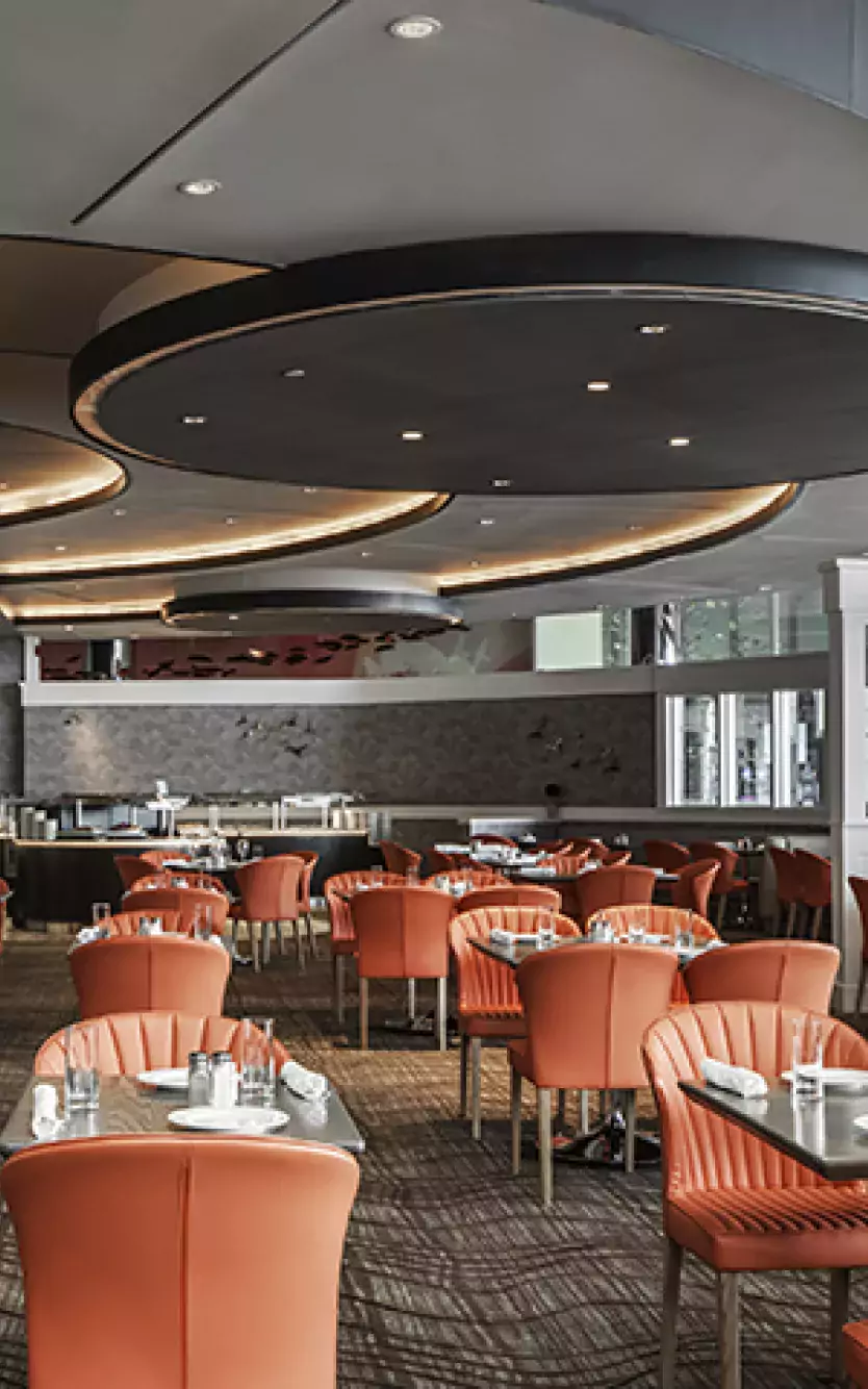 Sleek, modern dining room with tables and chairs and the {ma-kai} logo 